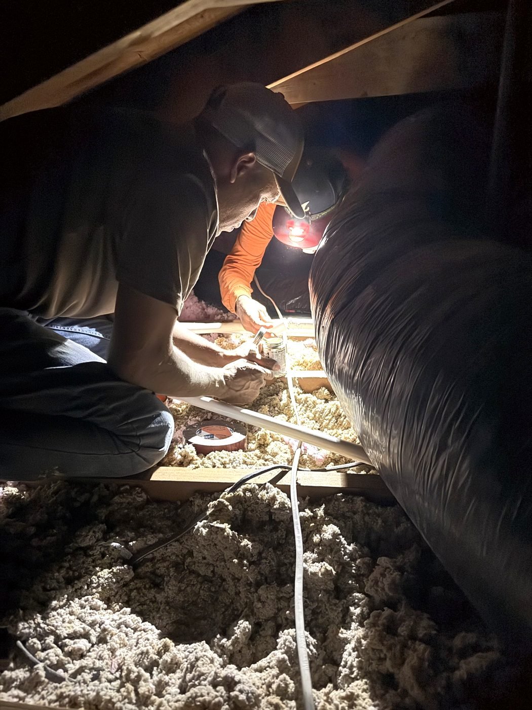 AtticPro technician air-sealing an attic before adding insulation