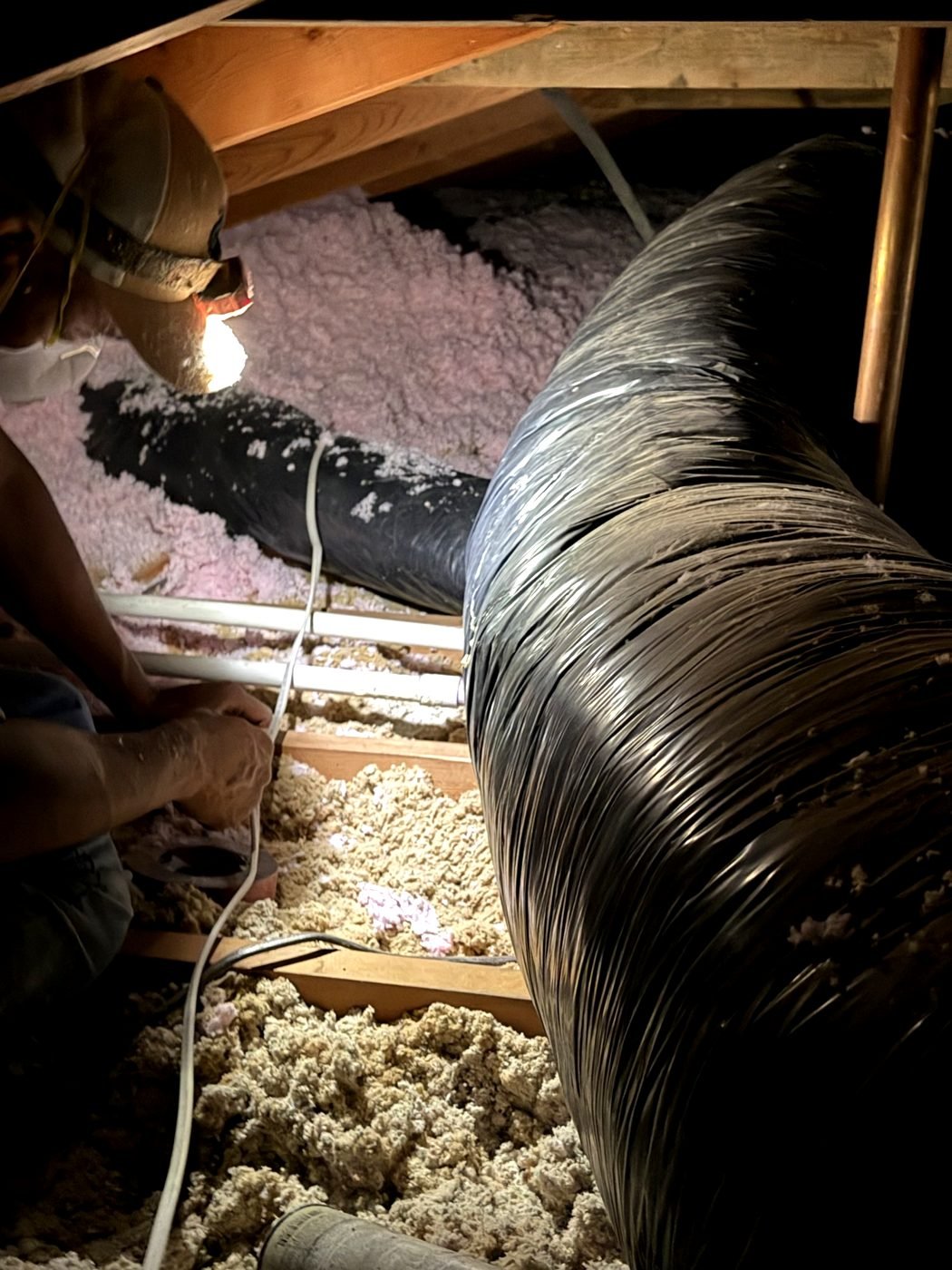 AtticPro crew working around attic ductwork during an insulation job